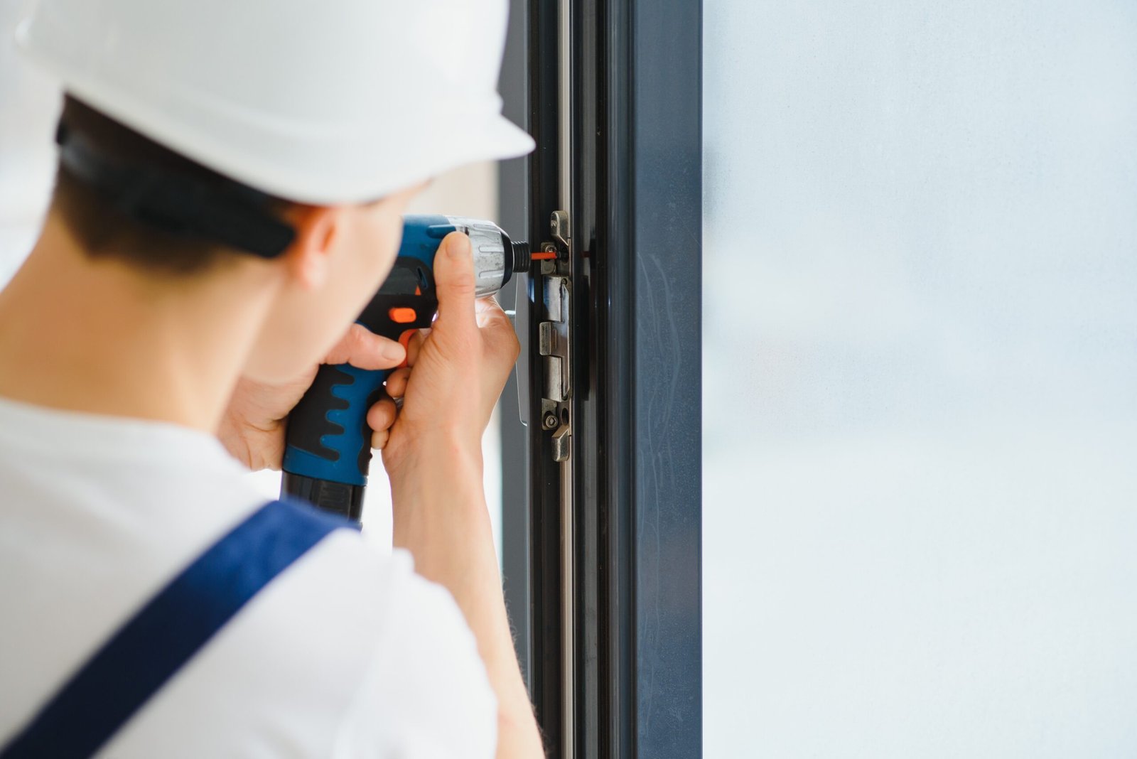 Construction worker installing window in house