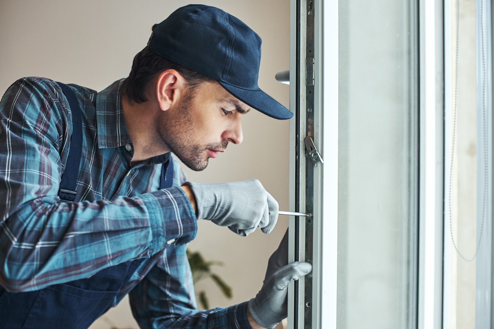 Master's work. Close-up of young handyman setting new windows at the appartment